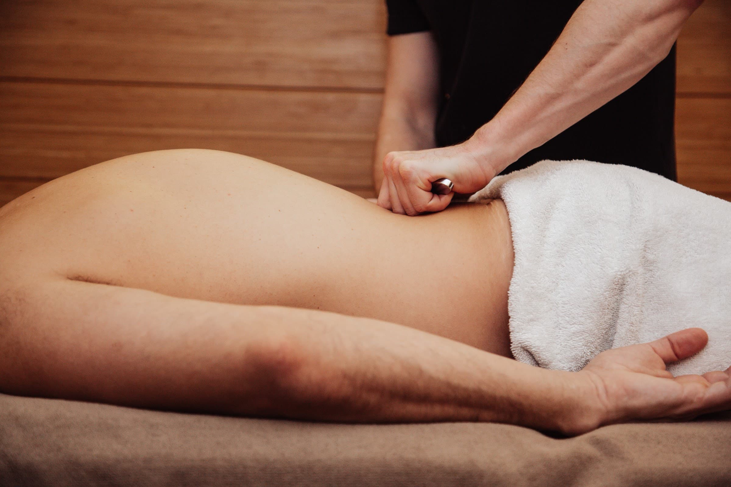 Physiotherapist applying hands-on massage to a client's lower back at SF Studios, Hampstead