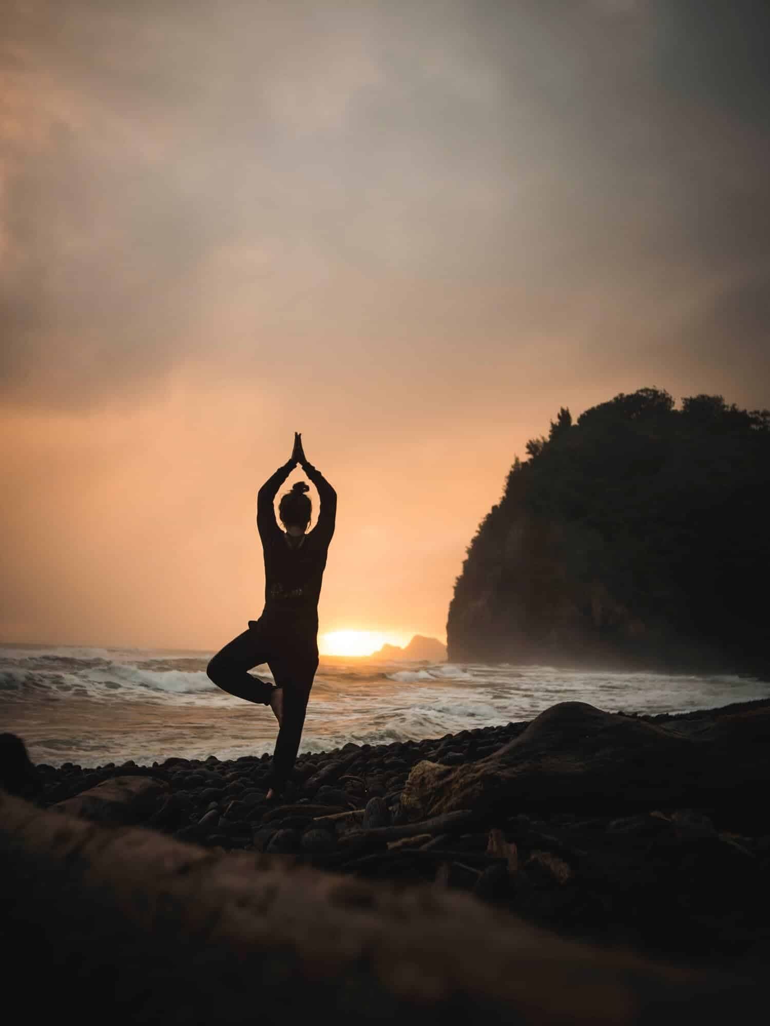girl posing in a yoga stand at the sea
