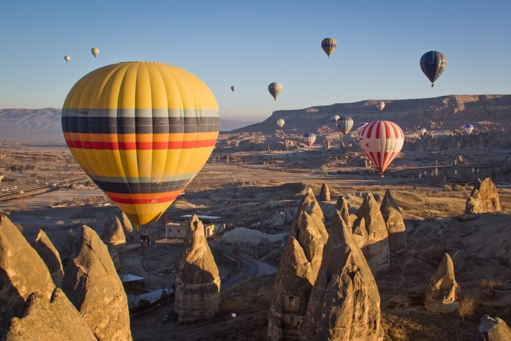 hot air balloons going over mountains