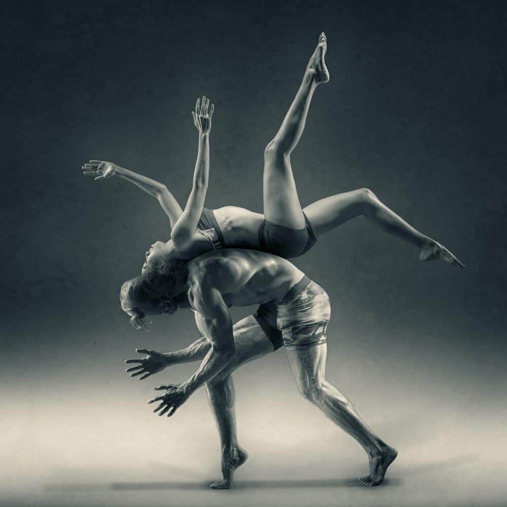 woman balancing on the back of a man
